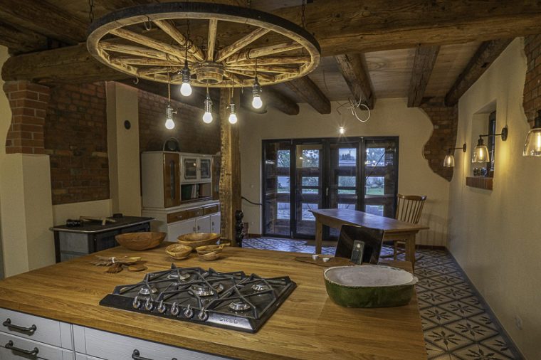 Moderne Küche mit Holzofen, offenem Raum und großen Fenstern.