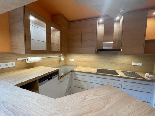 Moderne Küchenzeile aus Holz mit integrierten Geräten und warmer Beleuchtung.