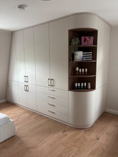 Moderne, helle Ecke mit Einbauschränken und einem offenen Regal für Kosmetikprodukte.